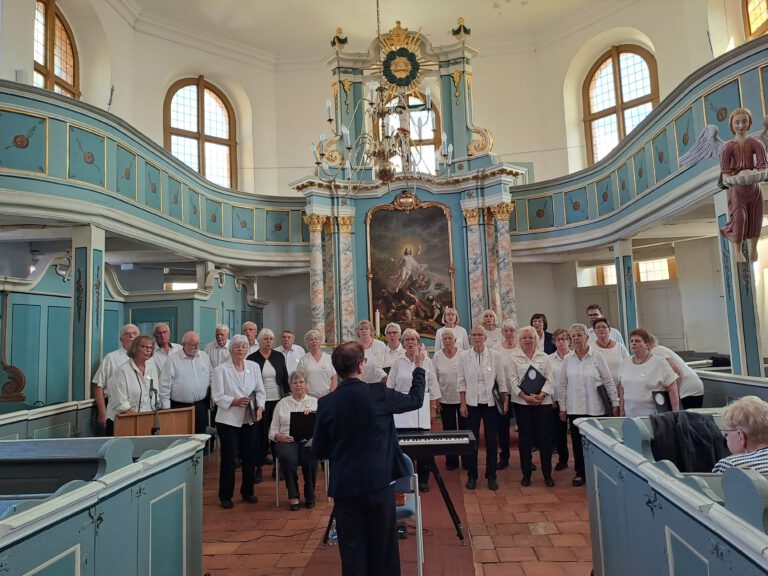 Der Chor singt sich vor dem Altar unter dem Taufengel ein