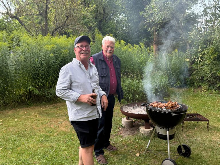 Ingo und Peter stehen am Kugelgrill im Garten