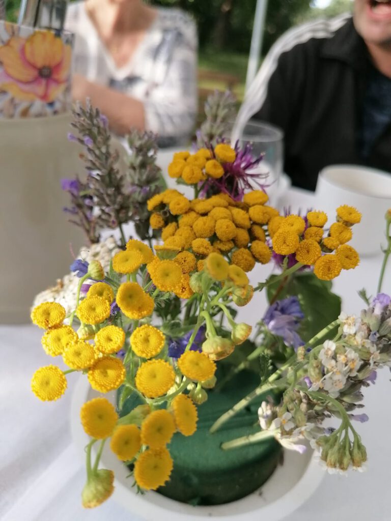 Ein Blumengesteck mit gelben Blüten als Tischschmuck